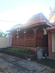 Casa con valla de madera y porche en Bharata Beach House, en Keramas