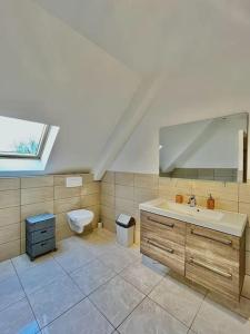 a bathroom with a sink and a toilet at Maison spacieuse de Lila avec 3 places de parkings in Crèvecoeur-le-Grand