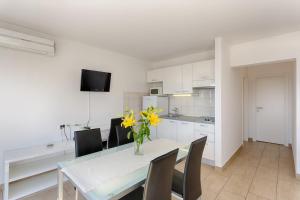 a kitchen and dining room with a table and yellow flowers at Adriatic Queen Residence in Split