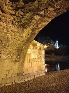 uma ponte de pedra à noite com um castelo ao fundo em Hotel Rural Virgen del Carmen em Molinaseca