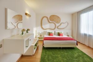 a white bedroom with a bed and a green rug at Best Western Plus Leone di Messapia Hotel & Conference in Lecce