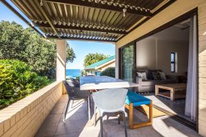 a patio with a table and chairs and a view of the ocean at Seaview Cottage Barry @ Surf Spray in Southbroom