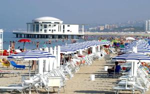 un montón de sillas y sombrillas en una playa en Villa al mare en Senigallia