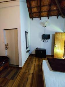 a bedroom with a bed and a wooden floor at Stillwater Homestay in Chikmagalūr