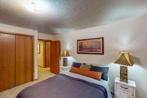 1 dormitorio con 1 cama de color púrpura y 2 lámparas en Nanacitas Casita en Greeley