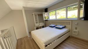 sypialnia z łóżkiem z niebieskimi poduszkami w obiekcie TERRASSES DE MALMEDY- CHALET 108 Le Chalet du Cerf & TRIPLEX 223 Le Refuge du Cerf w mieście Malmedy