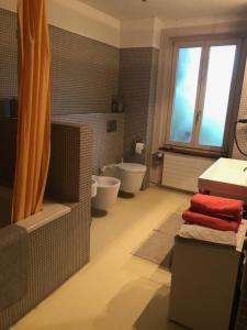 ein Badezimmer mit 2 WCs, einer Badewanne und einem Waschbecken in der Unterkunft B&B Winterthur in Winterthur