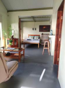 a bedroom with a bed and a couch and a table at The Green Shack in Quatre Soeurs