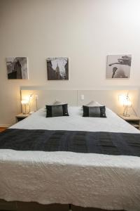 um quarto com uma grande cama branca e 2 almofadas em Botucatu Hotel em Botucatu