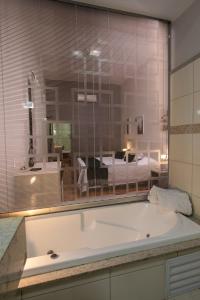 a large bath tub in a room with a bedroom at Botucatu Hotel in Botucatu