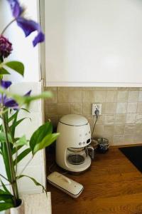 a coffee maker sitting on a counter with a flower at Tiny House Noordwijk aan Zee in Noordwijk