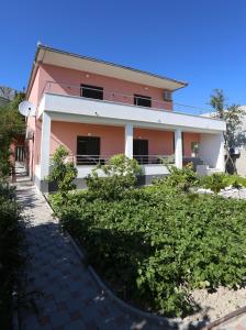 a pink house with bushes in front of it at Apartment Fila i Jure in Solin