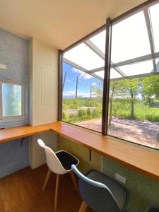 a room with a desk and two chairs and a window at Lily Garden Homestay in Yilan City