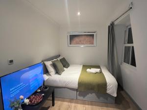 a small bedroom with a bed and a computer monitor at 3 Bedroom Flat in King’s Cross, St Pancras’s. 8 People in London