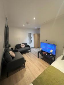 a living room with a couch and a large screen tv at 3 Bedroom Flat in King’s Cross, St Pancras’s. 8 People in London