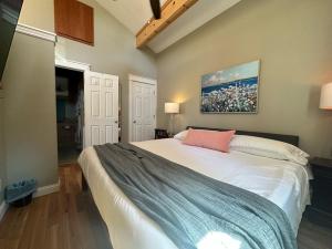 een slaapkamer met een groot wit bed en een roze kussen bij Luxury Smart Bungalow in Fayetteville