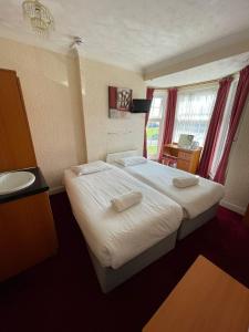 a bedroom with a bed and a sink in a room at Fjaerland Hotel in Great Yarmouth