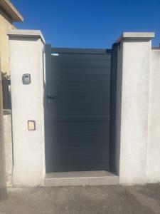 a black garage door on the side of a house at Beau studio indépendant à15mn de la plage, proche de toute commodité in Béziers
