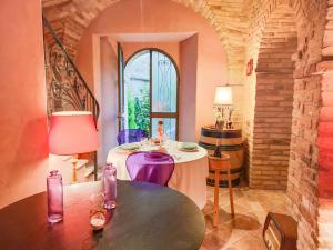 Cette chambre dispose d'une table avec des chaises violettes et d'une fenêtre. dans l'établissement La Scarpetta Magica: un incantevole soggiorno a 5 stelle!, à Offida