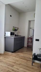 une cuisine avec évier et four micro-ondes sur un comptoir dans l'établissement appartamento Docfahouse, à Côme