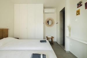 een slaapkamer met een bed en een spiegel aan de muur bij Villa Mare Incredible 3 bed villa private pool in Paleros