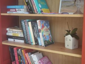 a book shelf filled with books and a potted plant at Dream House in Tsarevo