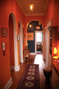 a hallway with orange walls and an entry way at Grand top floor apartment in the Royal Bank House in Maybole
