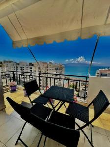 two chairs and a table on a balcony with the ocean at Albania Dream Apartment 31 in Metogjashta