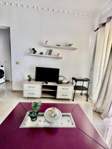 a living room with a tv and a purple rug at Albania Dream Apartment 31 in Metogjashta