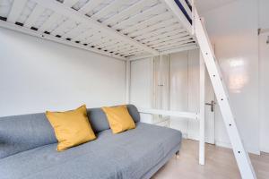 パリにあるStudio - Appartement Quartier Tour Eiffel 3のロフトベッド付きの客室で、ソファが備わります。