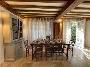 a dining room with a black table and chairs at Villa normande - Les Crapauds Fous - proximité Centre Ville et Plage in Deauville