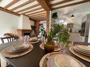 une table à manger avec des assiettes et un vase de fleurs dans l'établissement Villa normande - Les Crapauds Fous, à Deauville