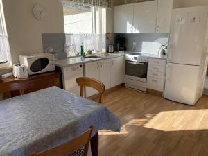 a kitchen with a table and a white refrigerator at House in the Westfjords in Súðavík