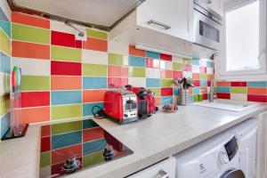 una cucina con piastrelle colorate sul muro di Studio - Appartement Quartier Tour Eiffel 3 Free Netflix a Parigi Altre 8 foto