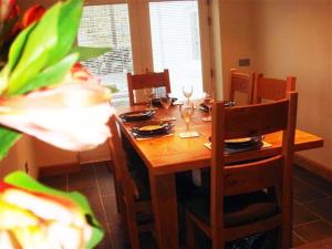 a dining room table with chairs and a wooden table with wine glasses at Criffel Glen in Dumfries
