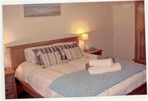 a bedroom with a bed with a lamp on a table at Criffel Glen in Dumfries