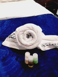 un asciugamano e due bottiglie di medicina su un letto di DESCANSO EN SUTATENZA BOYACA a Sutatenza