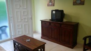 una sala de estar con TV en una cómoda de madera en Apartamentos Silken Playa de Toró, en Llanes