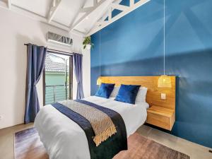 a blue bedroom with a large bed with blue walls at Virginia Avenue Villas - Adriatica and Botanica in Cape Town