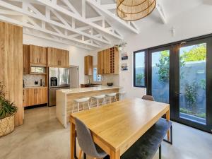 cocina y comedor con mesa de madera en Virginia Avenue Villas - Adriatica and Botanica, en Ciudad del Cabo