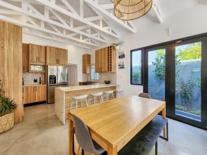 a kitchen and dining room with a wooden table at Virginia Avenue Villas - Adriatica and Botanica in Cape Town