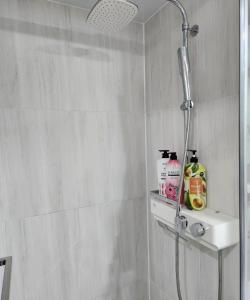 a shower in a bathroom with a sink and a shower head at For you House in Daegu