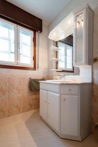 a white bathroom with a sink and a mirror at Casa Bella Lalin- 4 Double bedroom Galician Country Home! in Pontevedra