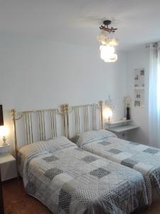 2 camas en un dormitorio blanco con 2 lámparas en Full rental or by areas. Barbecue, Gardens, Large Terraces, Three rooms, en Beniatjar