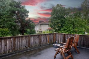 un patio con una valla de madera y 2 sillas en Cozy House en Oslo