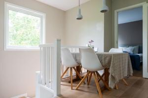 a dining room with a table and four white chairs at Cozy House in Oslo