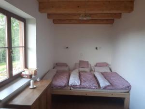 una cama sentada en una habitación junto a una ventana en Zlatak holiday house en Malá Morava