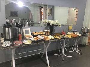 a table with a bunch of food on it at Hotel Caçula in Londrina