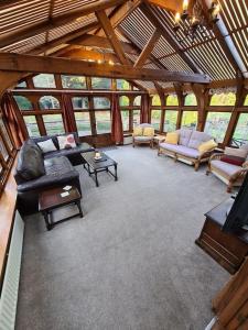 a living room with couches and tables in a building at Beautiful thatched cottages in Brentwood. in Kelvedon Hatch