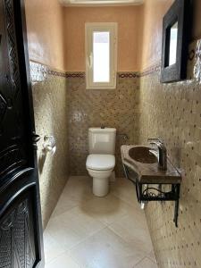 a bathroom with a toilet and a sink at Triplex & Pool Tiguert in Agadir